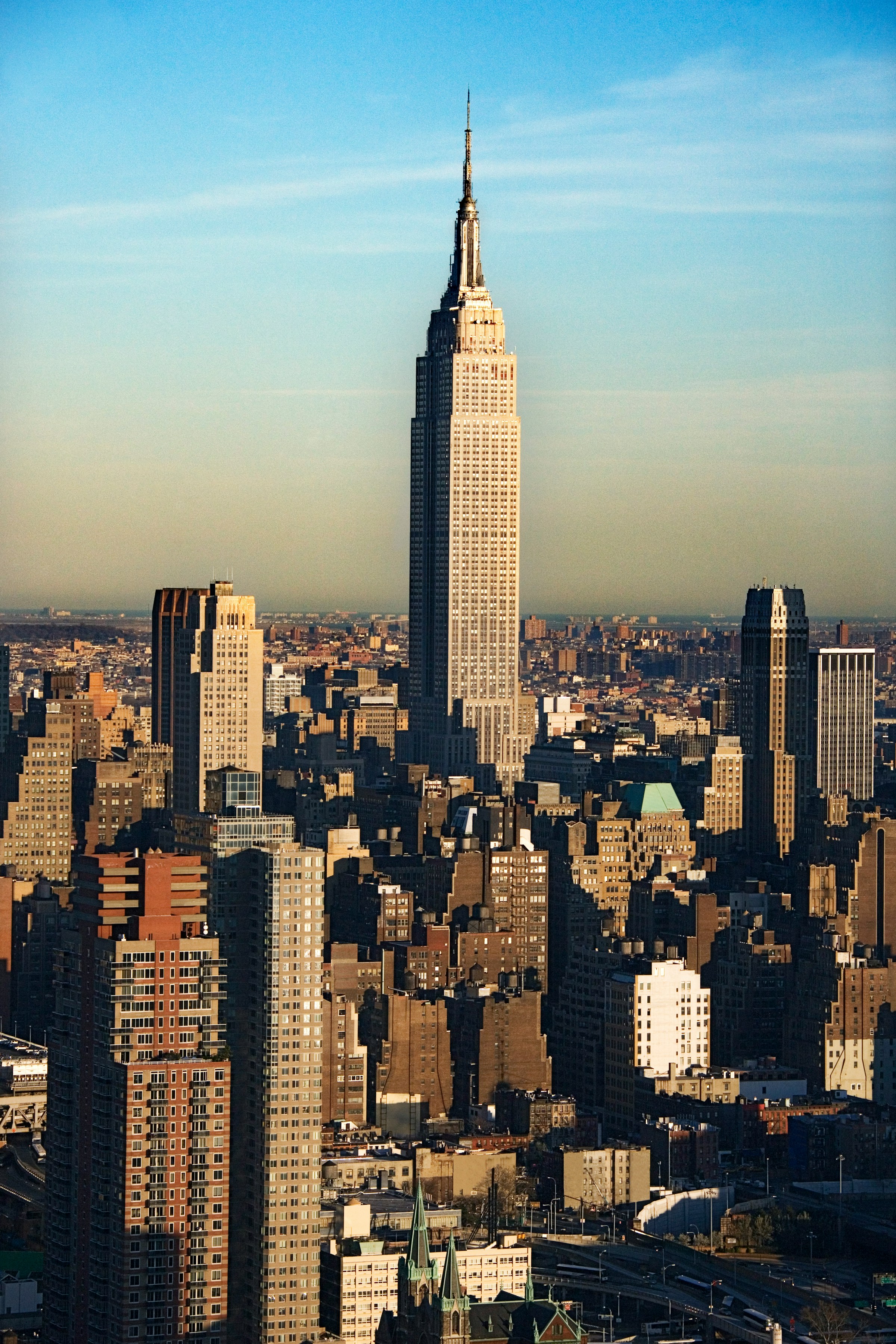 Iconic Empire State Building amidst New York City skyline during daytime.