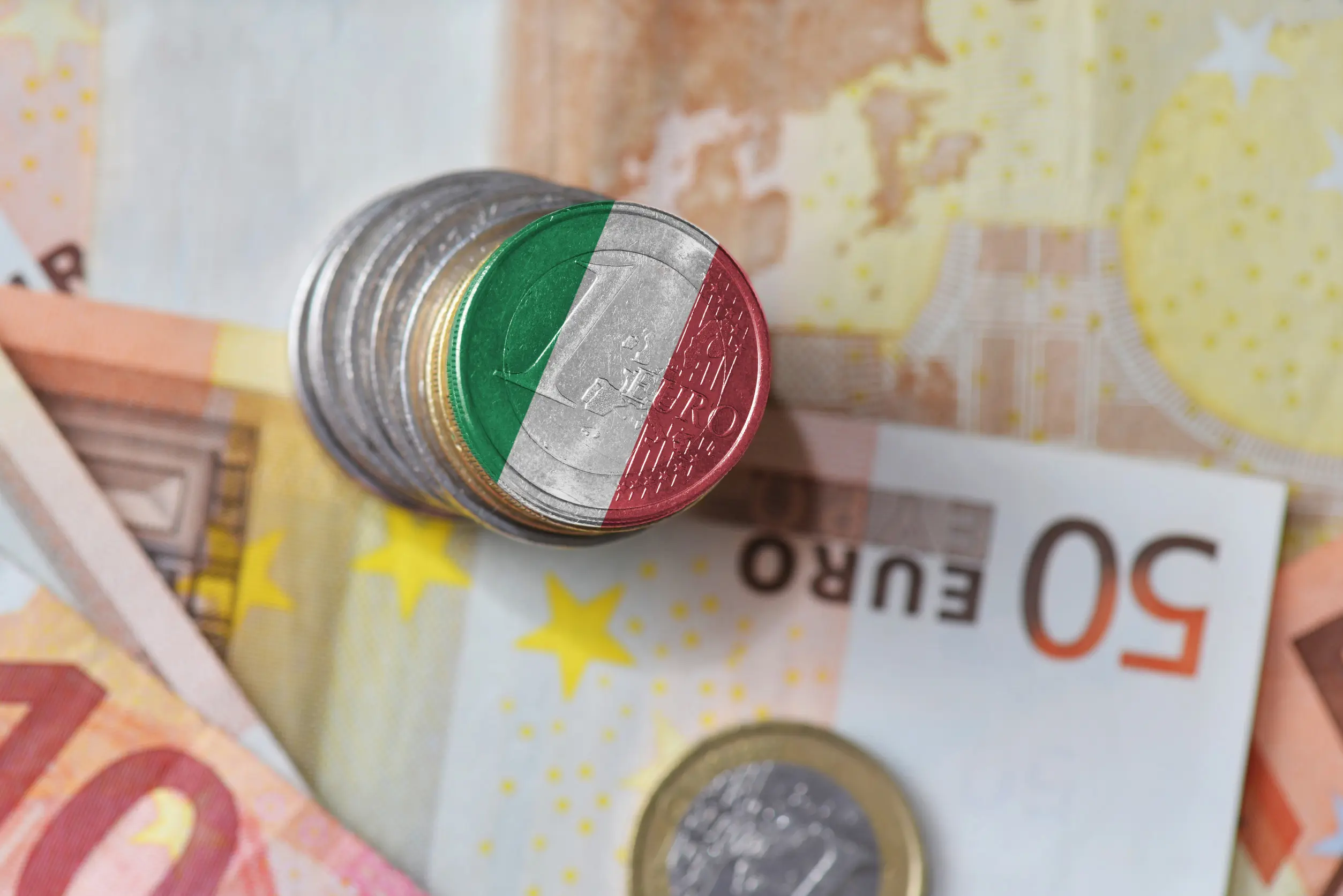 Italienska eurocentmynt staplade på euro sedlar, visar Italiens flagga.