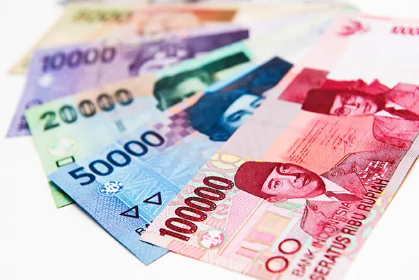 Indonesiska rupiah-sedlar i olika valörer ligger utspridda.
