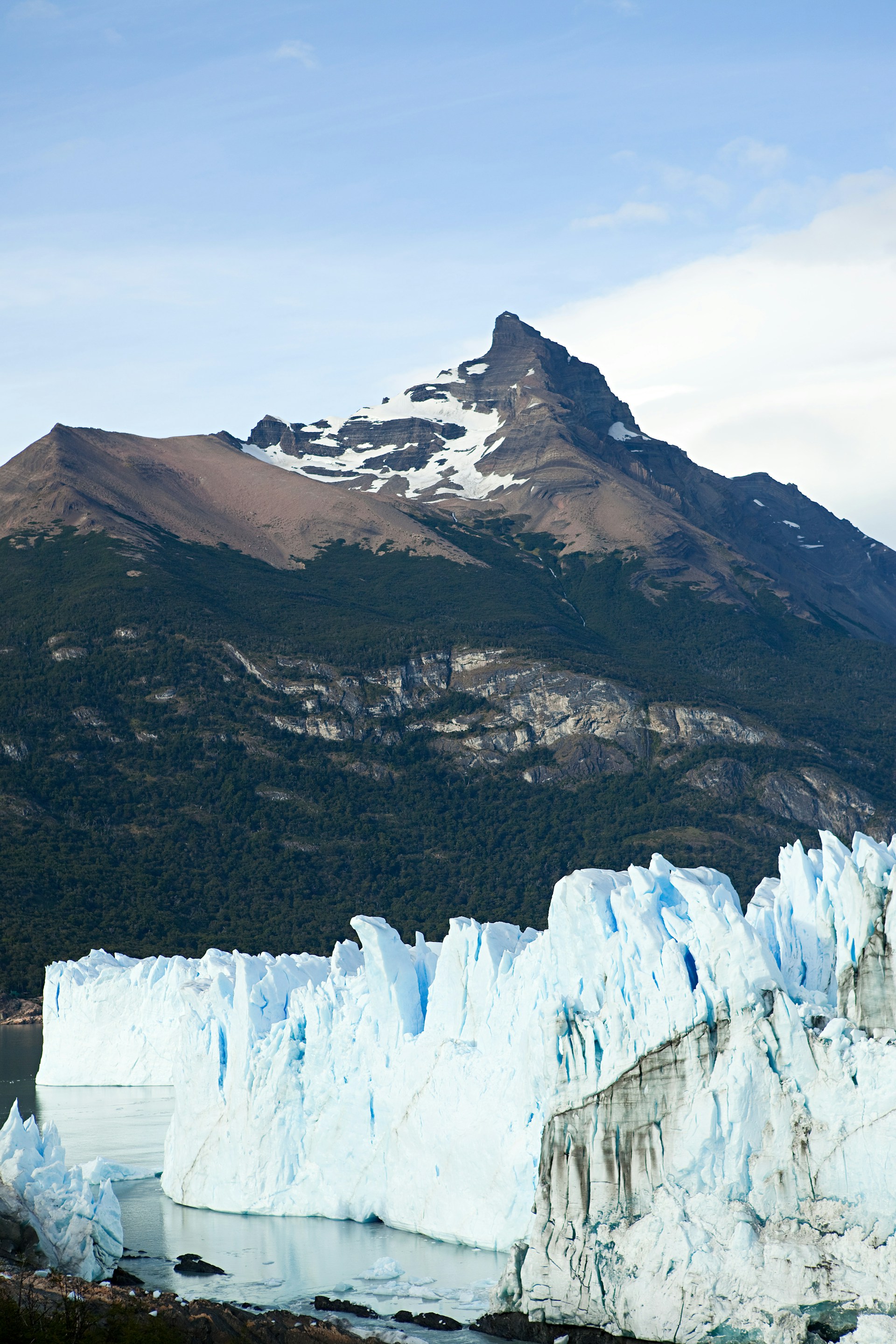 Glaciär med berg i bakgrunden under klarblå himmel i Patagonien