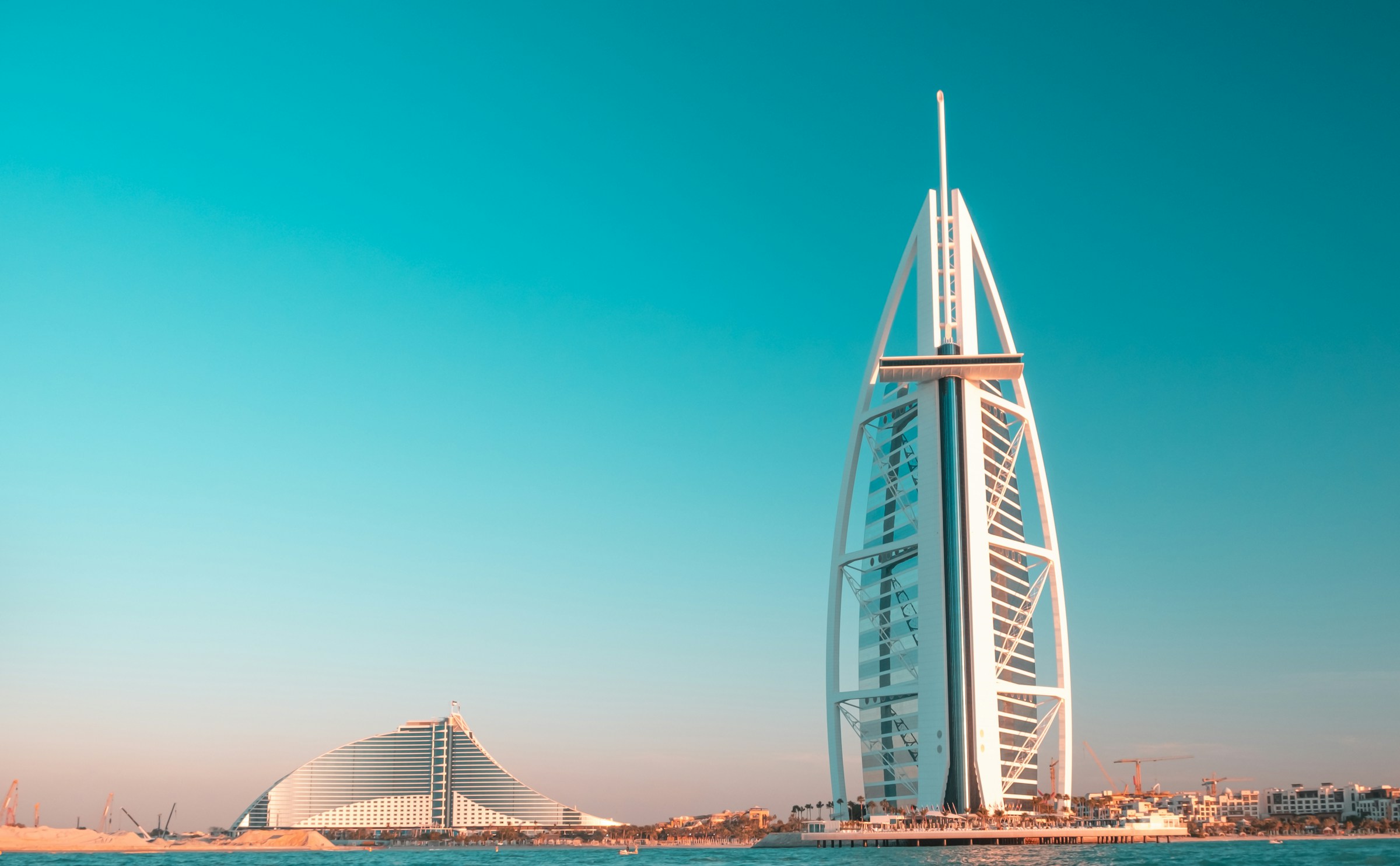 Iconic Burj Al Arab hotel in Dubai, UAE, with clear blue sky background.