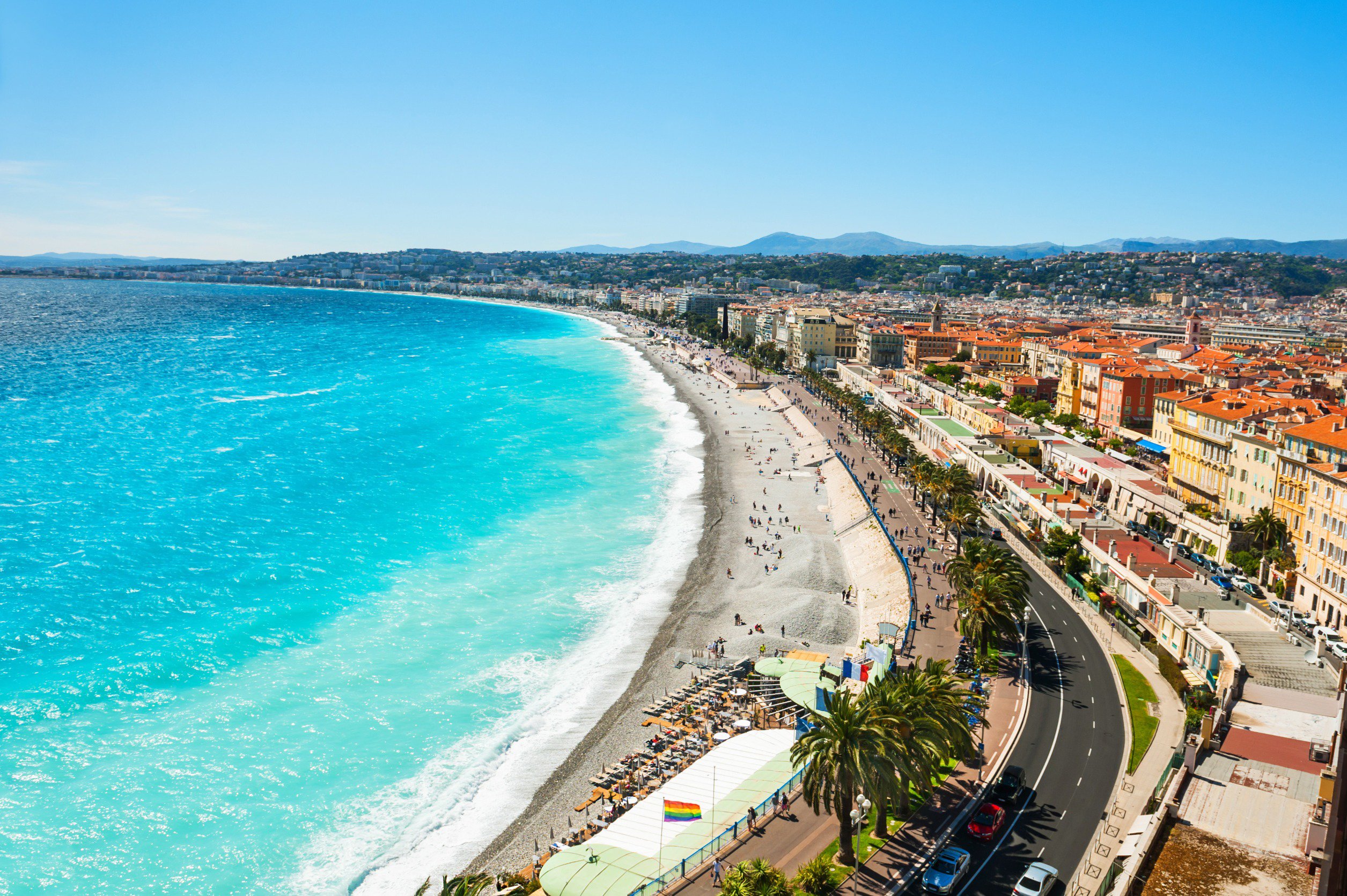 Travel to Nice, France - Showing the Promenade des Anglais along the Mediterranean coast with turquoise waters, sandy beaches, and vibrant cityscape.