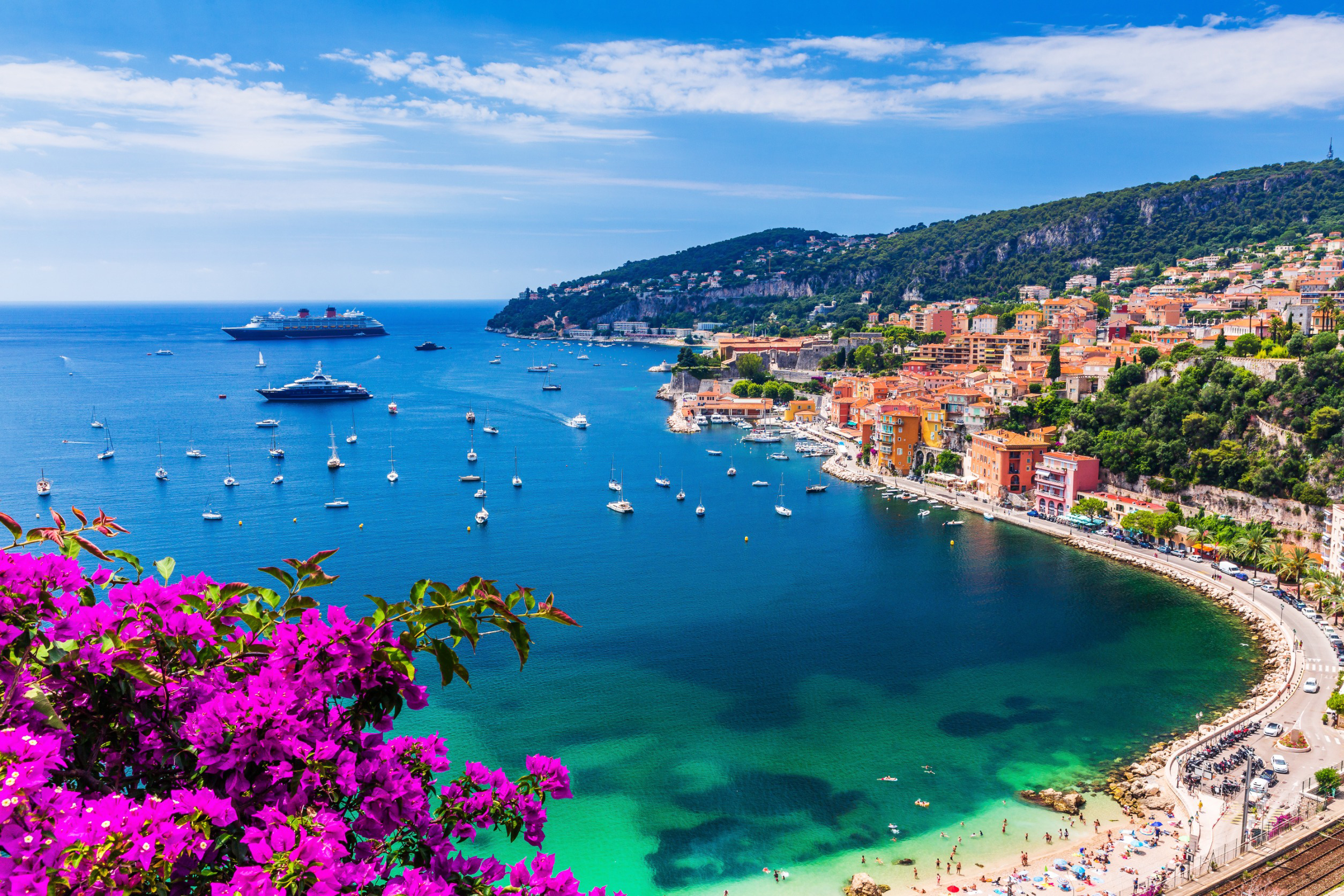 Travel to the French Riviera - Bay with blue sea and boats, greenery and pebble beach all around