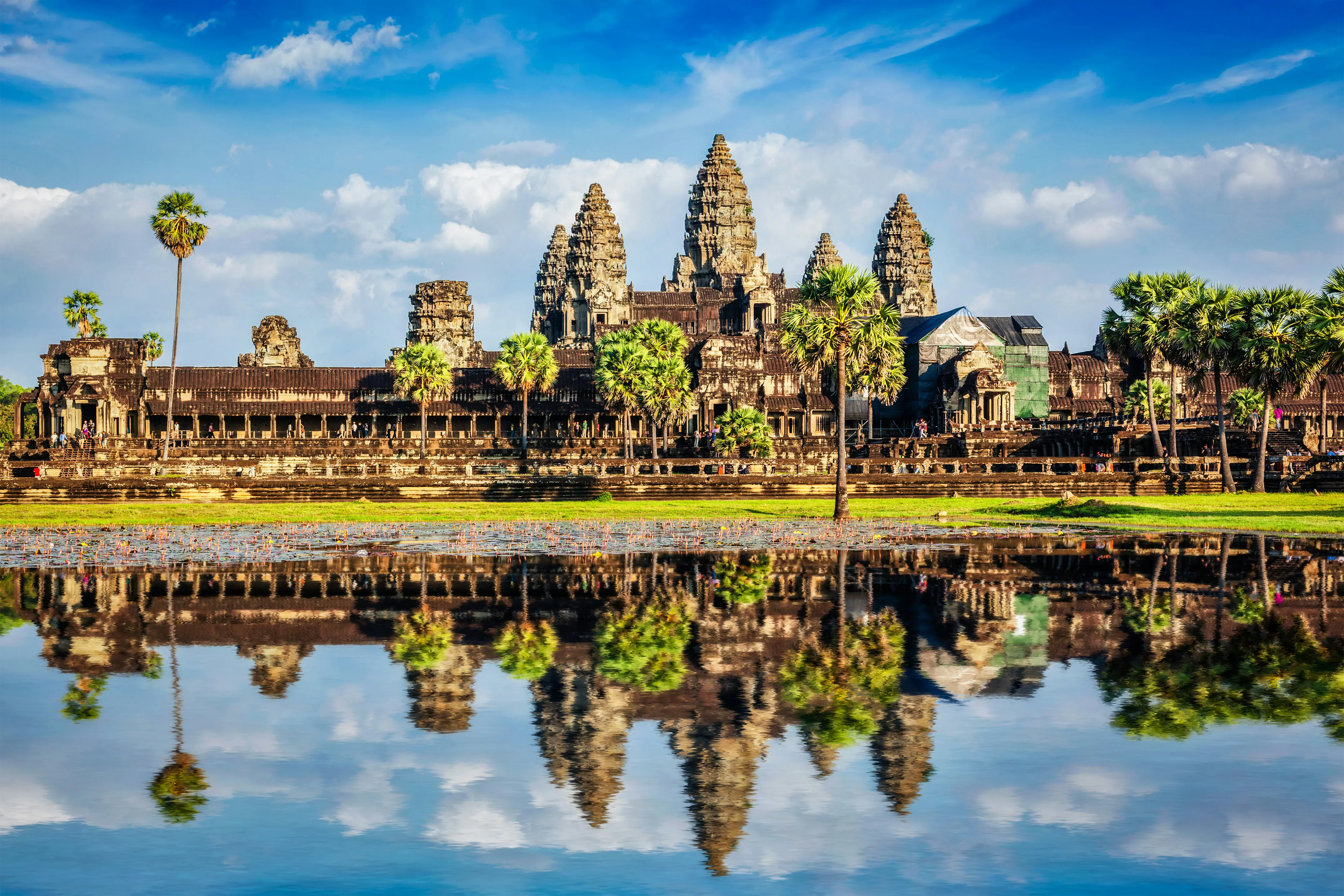 Angkor Wat -temppeli Kambodžassa, kirkkaan sininen taivas taustana ja temppelin heijastus vedessä etualalla