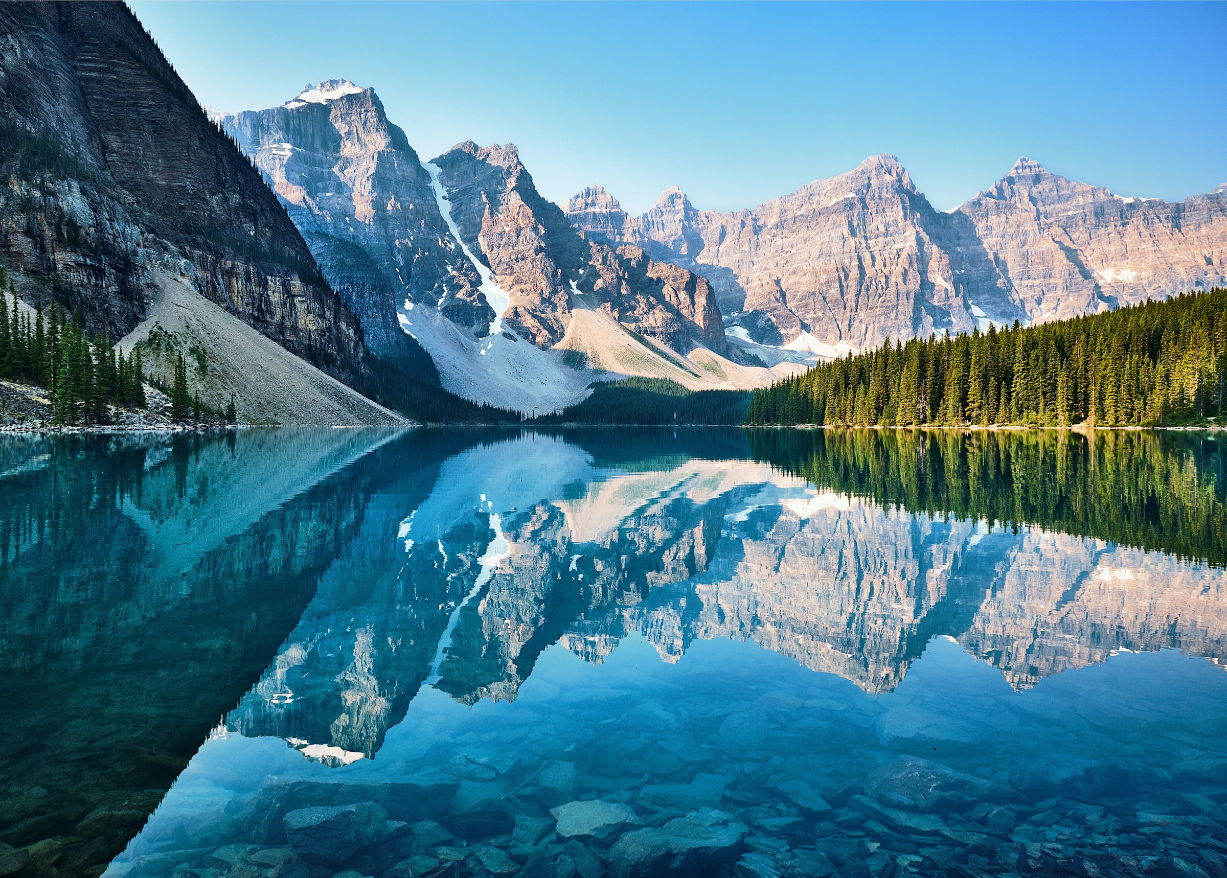 Scenic view of Moraine Lake in Banff National Park, Canada, with turquoise waters reflecting snow-capped Rocky Mountains.