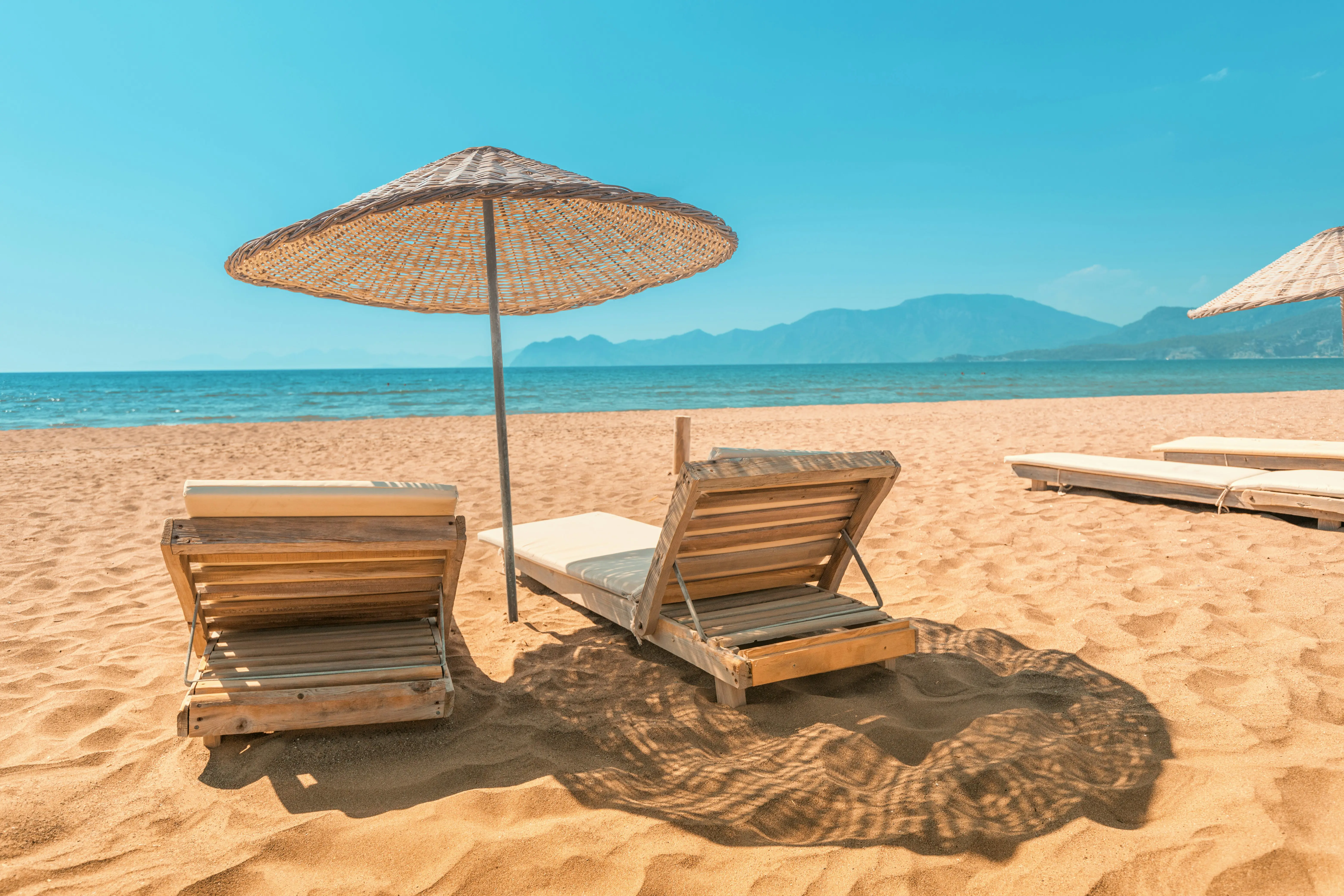 Sun loungers on a beach with the sea in the background in the Caribbean