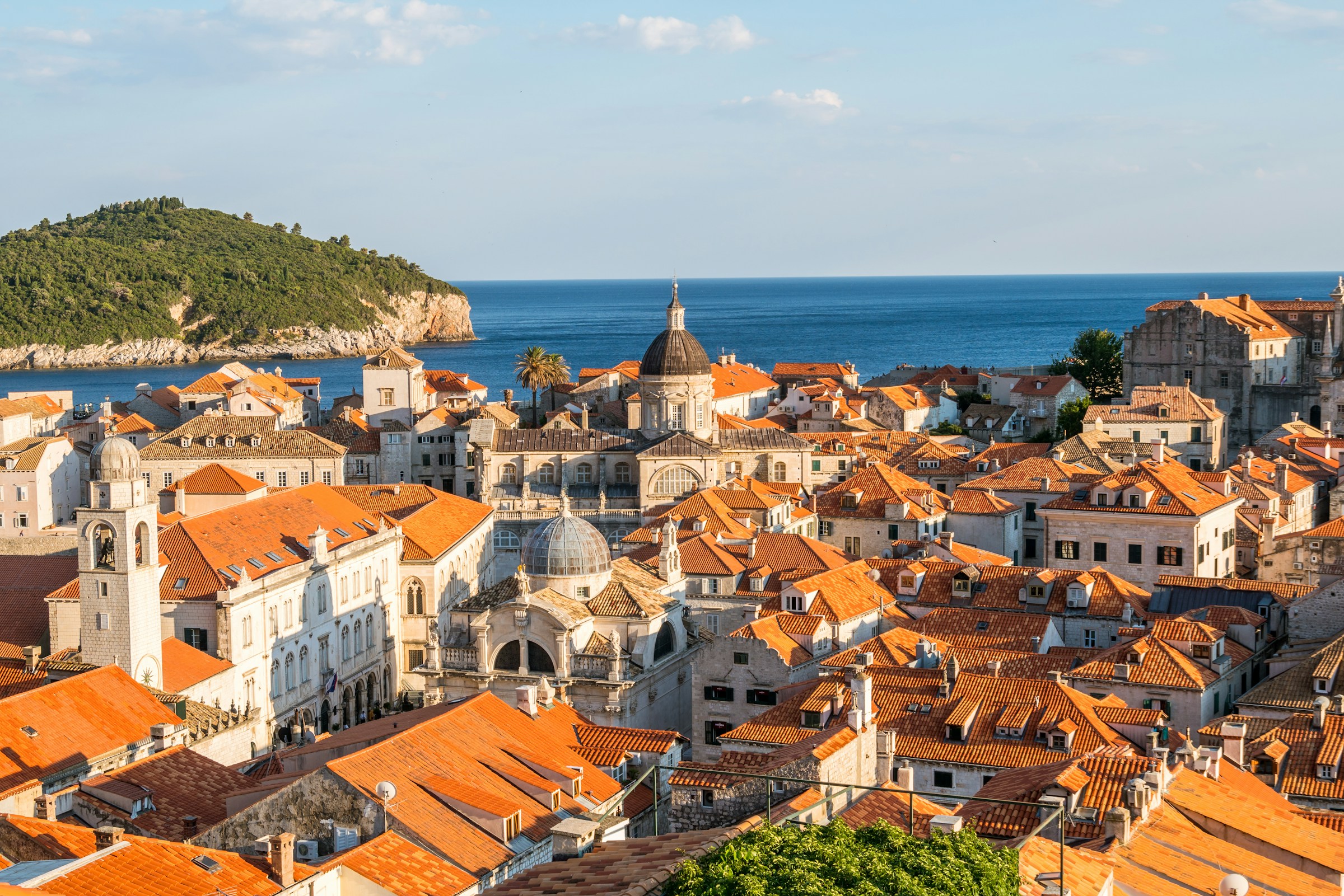 Aerial view of Dubrovnik, Croatia, showcasing its iconic red-tiled roofs, historic architecture, and the Adriatic Sea in the background