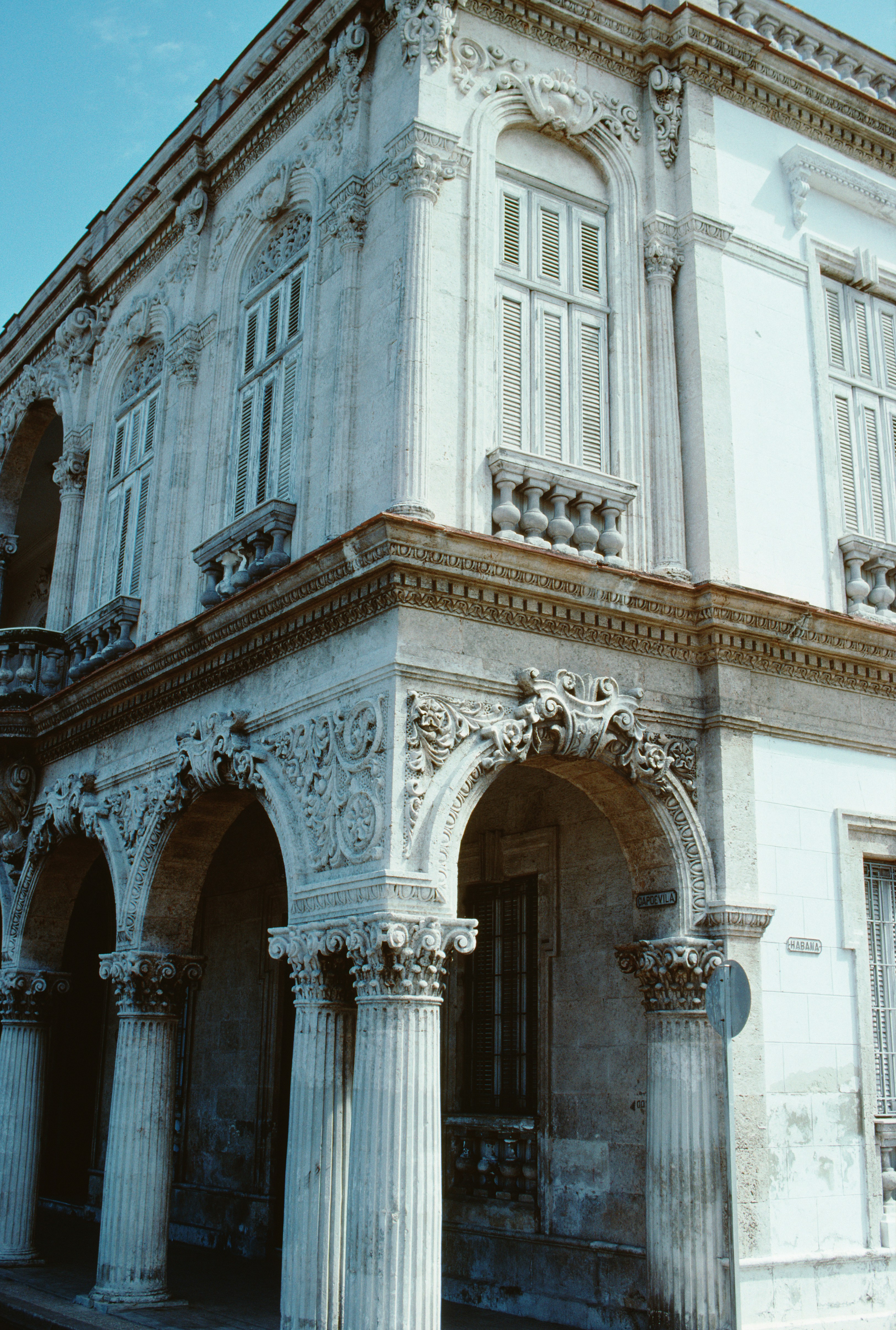 Historisk byggnadsfasad med utsmyckade kolonner och valv, med detaljerade stenhuggningar och klassiska arkitektoniska detaljer