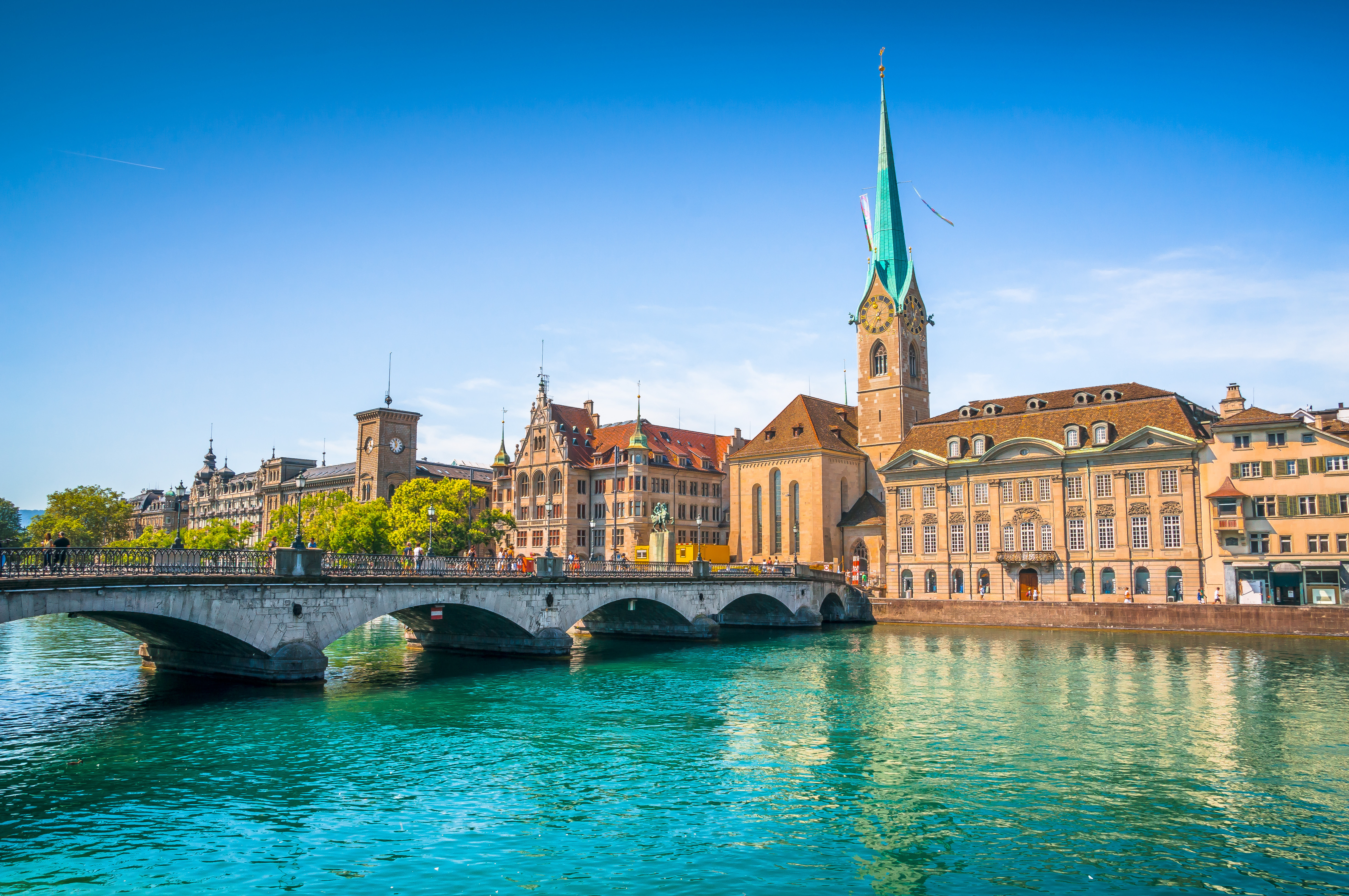 Historic Fraumünster Church and Limmat River in Zurich, Switzerland under a clear blue sky