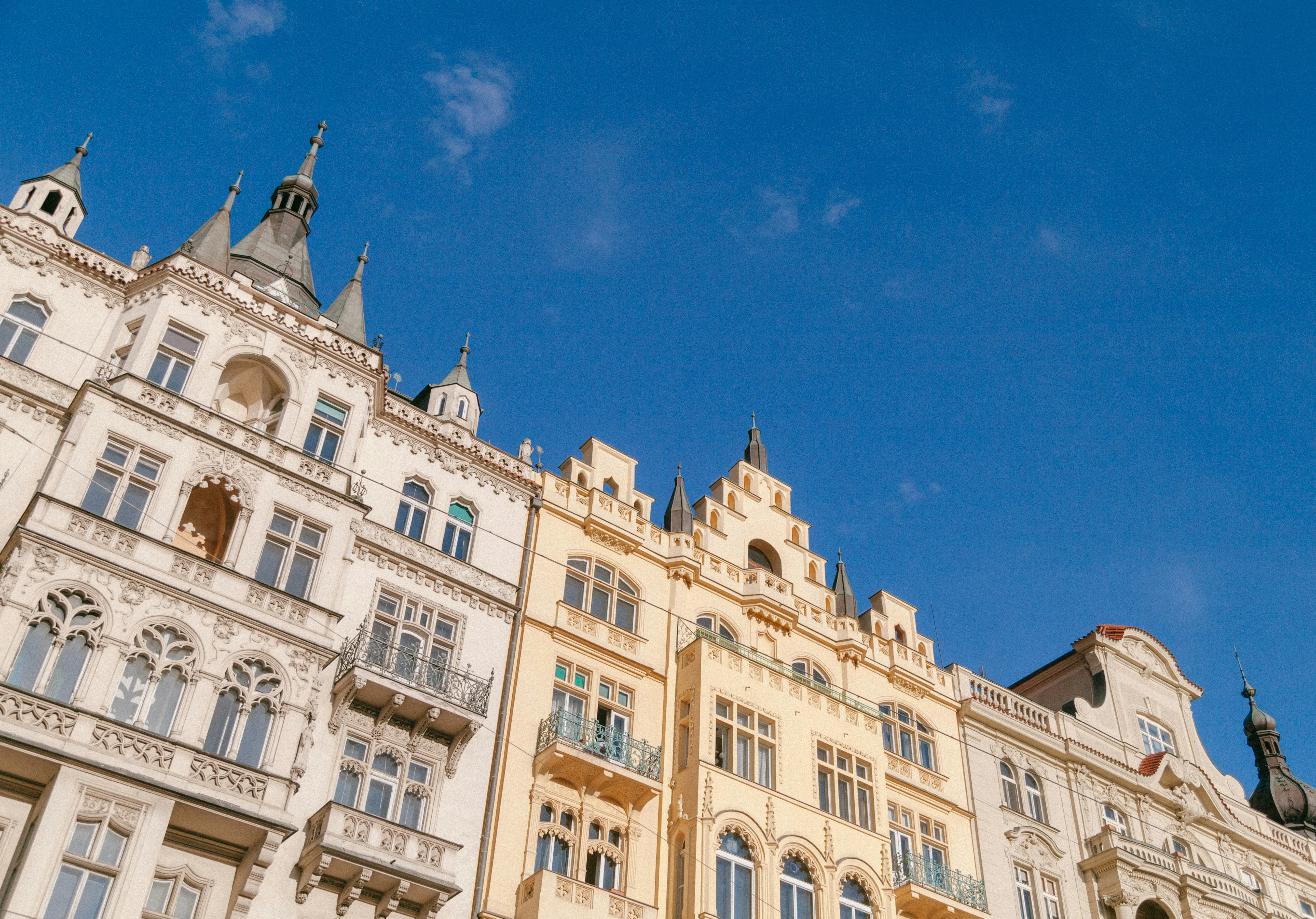 Historisk europeisk arkitektur mot en klarblå himmel med utsmyckade fasader och stiliserade spiror