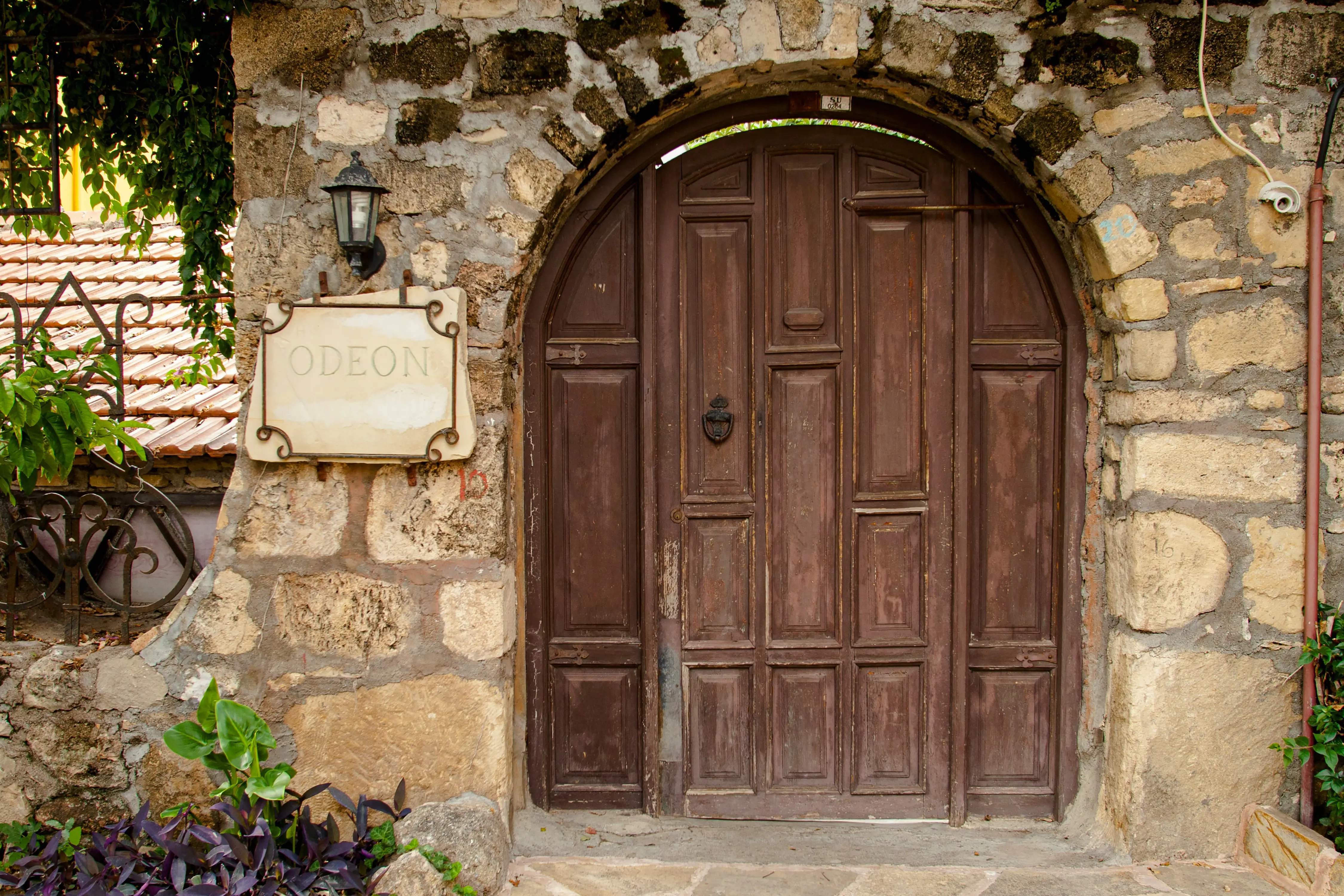 Vanha puinen ovi kiviseinässä, jossa kyltti tekstillä "Odeon"