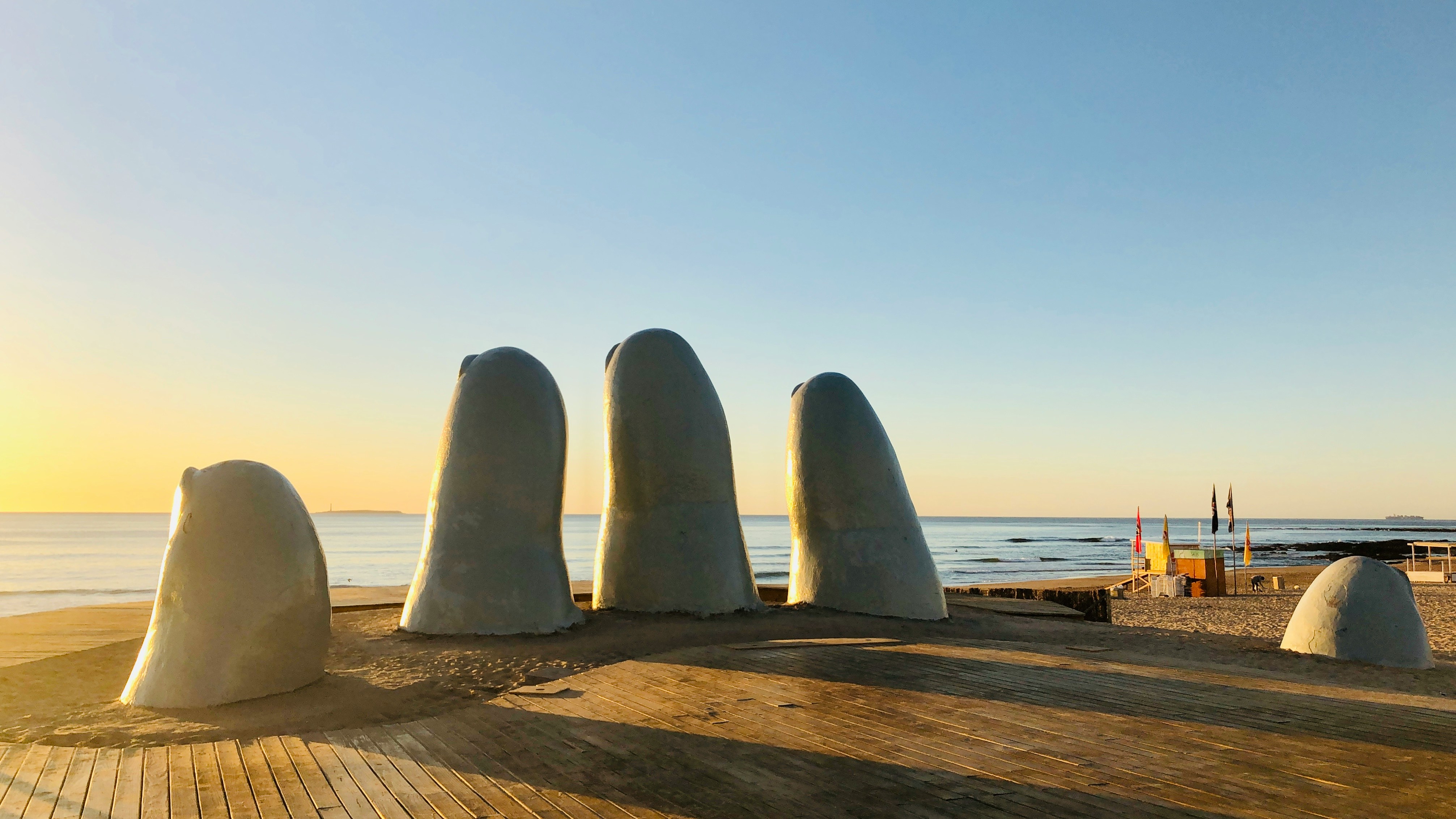 Giant hand sculpture on sandy beach at sunrise, Punta del Este, Uruguay